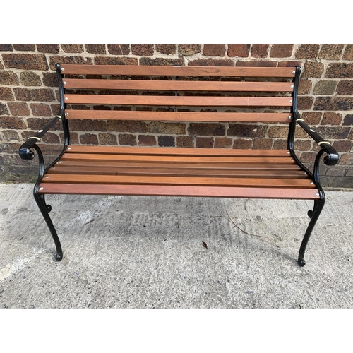 39 - A cast iron and wooden slatted garden bench - approx. 80cm high x 126cm wide x 44cm deep