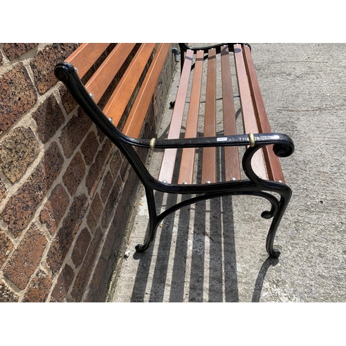 39 - A cast iron and wooden slatted garden bench - approx. 80cm high x 126cm wide x 44cm deep