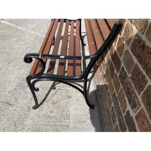 39 - A cast iron and wooden slatted garden bench - approx. 80cm high x 126cm wide x 44cm deep