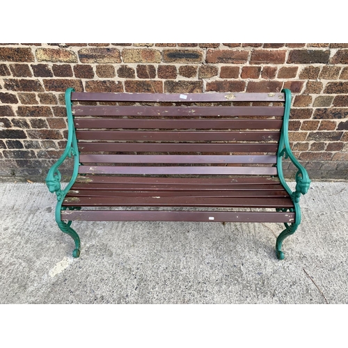 43 - A cast iron and wooden slatted garden bench - approx. 81cm high x 126cm wide x 46.5cm deep