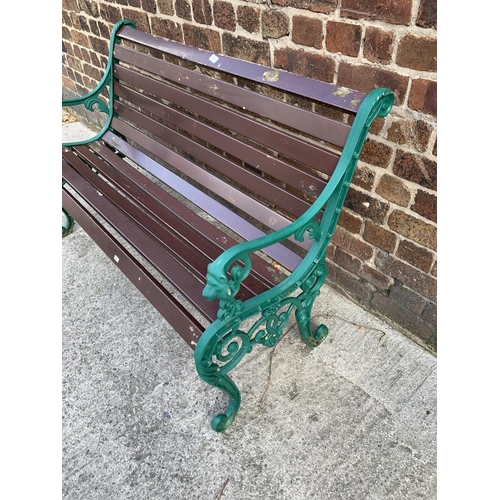 43 - A cast iron and wooden slatted garden bench - approx. 81cm high x 126cm wide x 46.5cm deep