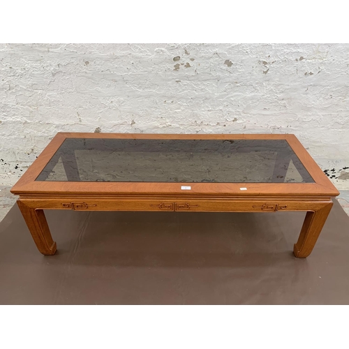 47 - A Chinese carved hardwood and smoked glass rectangular coffee table - approx. 40cm high x 127cm long... 