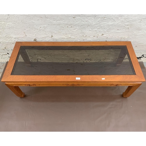 47 - A Chinese carved hardwood and smoked glass rectangular coffee table - approx. 40cm high x 127cm long... 