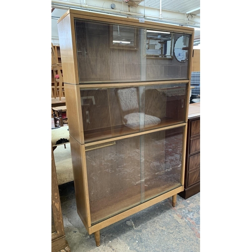 60 - A mid 20th century light oak three section stacking bookcase with sliding glazed doors - 144cm high ... 