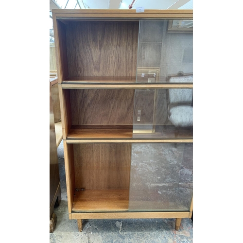 60 - A mid 20th century light oak three section stacking bookcase with sliding glazed doors - 144cm high ... 