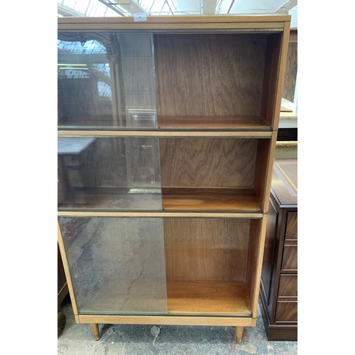 60 - A mid 20th century light oak three section stacking bookcase with sliding glazed doors - 144cm high ... 