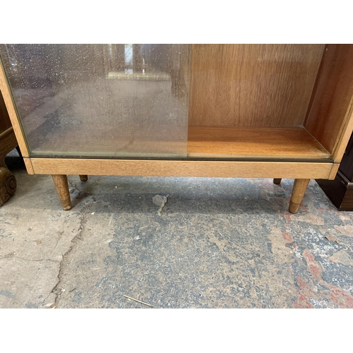 60 - A mid 20th century light oak three section stacking bookcase with sliding glazed doors - 144cm high ... 