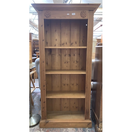 62 - A pine four tier free standing bookcase - approx. 155cm high x 77cm wide x 27.5cm deep