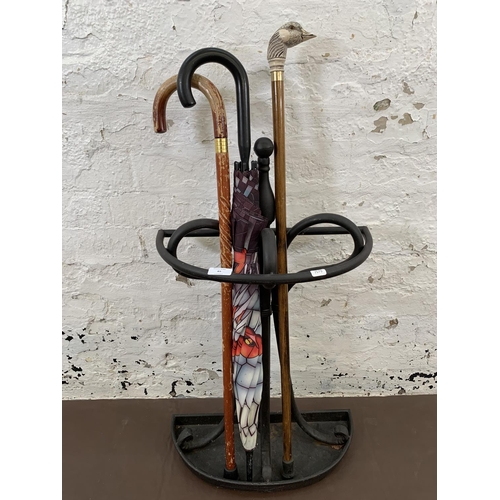 85 - A black painted metal stick stand - approx. 75cm high x 43cm wide together with two walking canes an... 