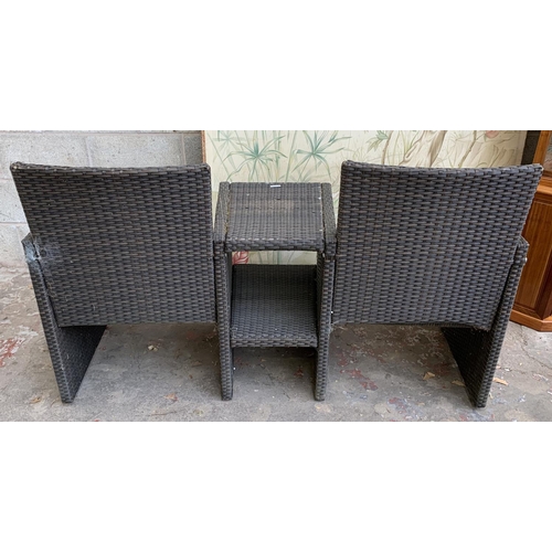 87 - A plastic rattan effect two seater garden bench with central two tier table - approx. 85cm high x 14... 