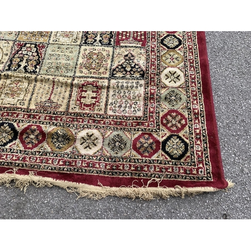 91 - A large machine woven red and cream rug - approx. 333cm long x 234cm wide