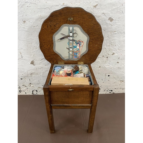 98 - A 1940s oak sewing table and contents - approx. 46cm high x 49cm diameter