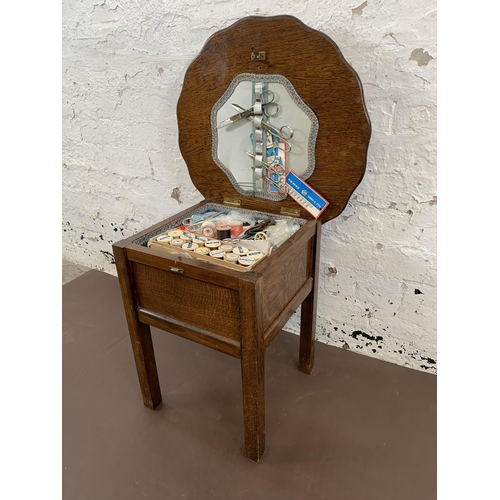 98 - A 1940s oak sewing table and contents - approx. 46cm high x 49cm diameter