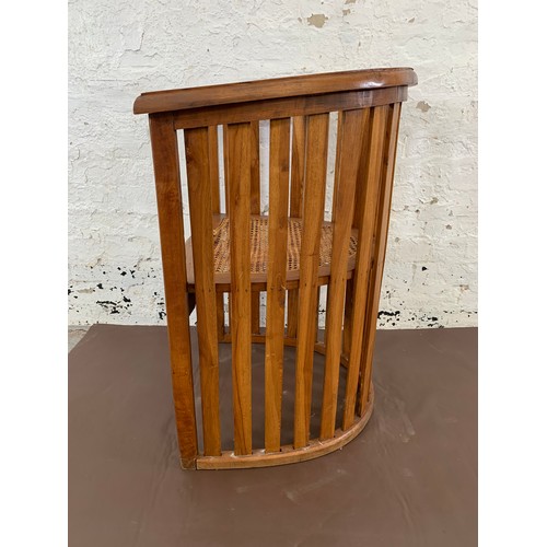 151 - A teak and rush seated barrel back armchair - approx. 85cm high x 65cm wide x 48cm deep