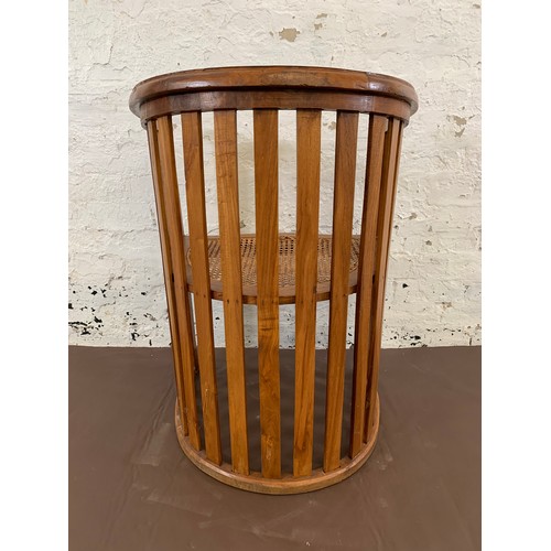 151 - A teak and rush seated barrel back armchair - approx. 85cm high x 65cm wide x 48cm deep