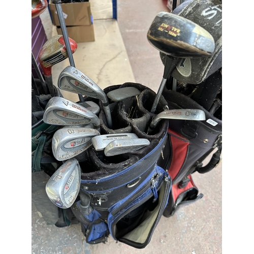 1022 - Three golf bags containing clubs to include Slazenger, Wilson, Hippo, Callaway etc.