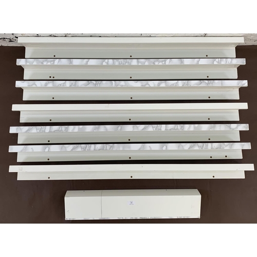 107 - A set of eight Ikea white laminate wall hanging shelves - largest approx. 115cm long