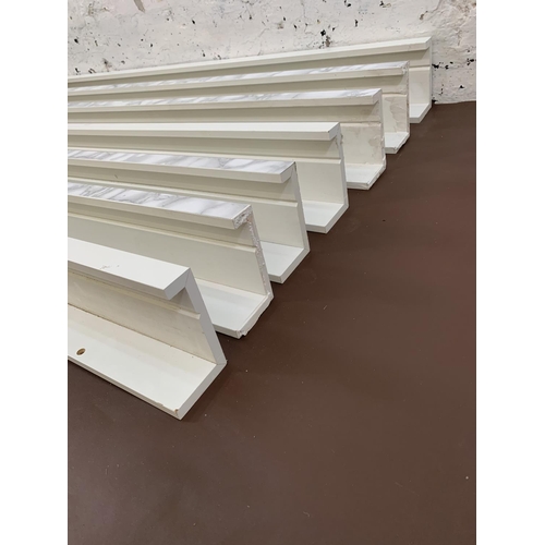 107 - A set of eight Ikea white laminate wall hanging shelves - largest approx. 115cm long