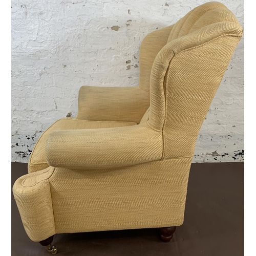 152 - A 19th century style yellow upholstered wing and button back armchair - approx. 109cm high x 86cm wi... 