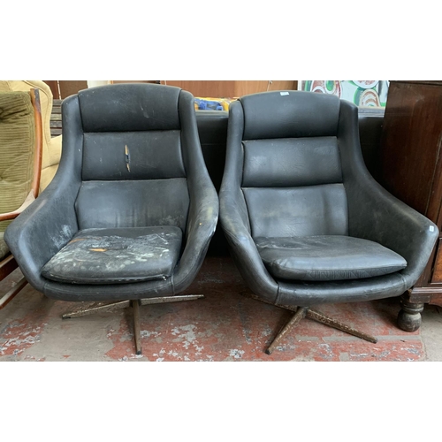 173 - A pair of 1960s black vinyl and fibreglass swivel egg chairs - approx. 93cm high x 77cm wide