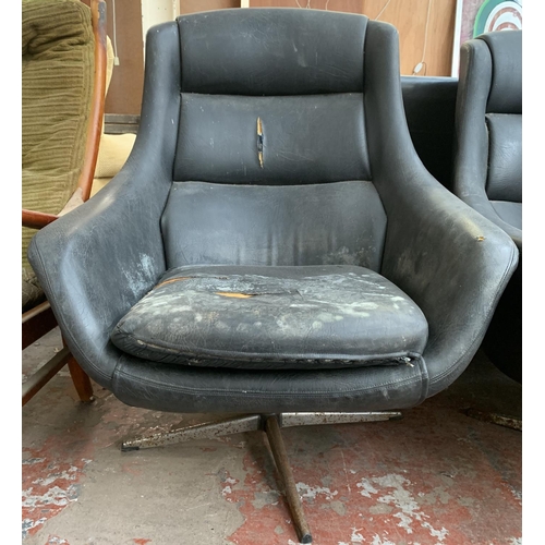 173 - A pair of 1960s black vinyl and fibreglass swivel egg chairs - approx. 93cm high x 77cm wide