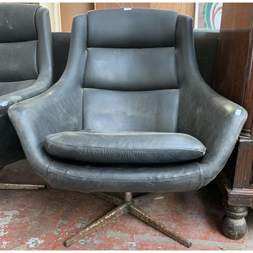 173 - A pair of 1960s black vinyl and fibreglass swivel egg chairs - approx. 93cm high x 77cm wide