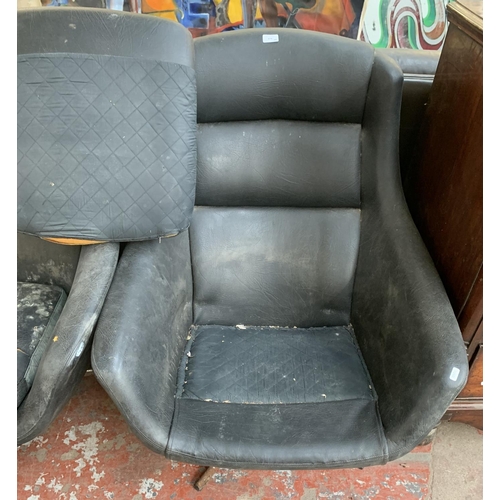 173 - A pair of 1960s black vinyl and fibreglass swivel egg chairs - approx. 93cm high x 77cm wide