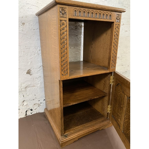 194 - A carved oak single door cabinet - approx. 84cm high x 44cm wide x 41cm deep