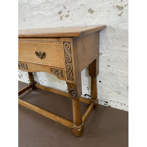 200 - A carved oak hall table with lower stretchers and one drawer - approx. 68cm high x 92.5cm long x 36.... 