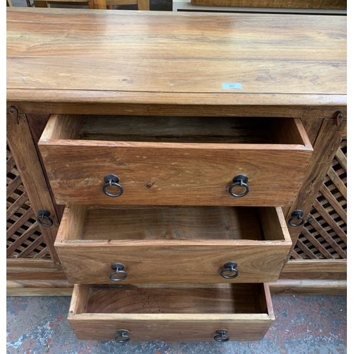 207 - An Indonesian hardwood sideboard with two latticework cupboard doors and three central drawers - app... 