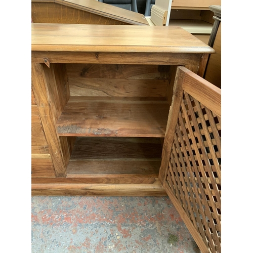 207 - An Indonesian hardwood sideboard with two latticework cupboard doors and three central drawers - app... 