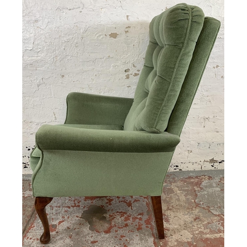 227 - A pair of vintage green fabric upholstered button back armchairs on cabriole supports - approx. 107c... 