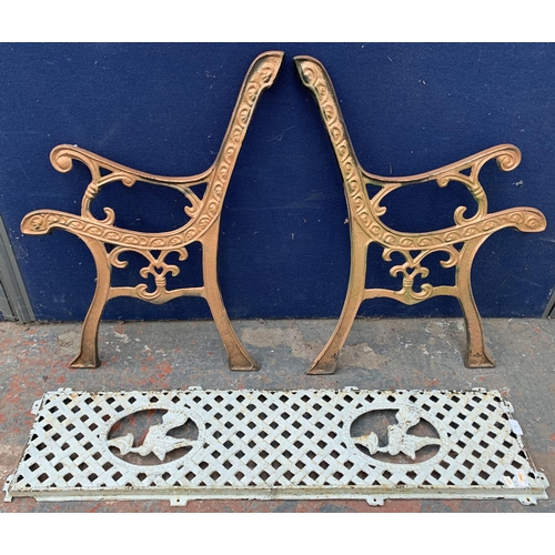 34 - Two cast iron garden bench accessories, one pair of bench ends and one bench back support