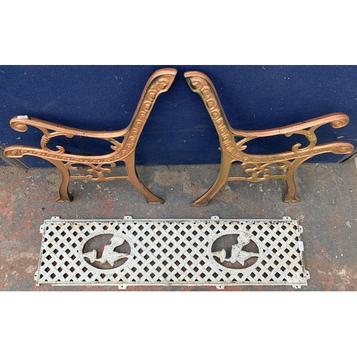 34 - Two cast iron garden bench accessories, one pair of bench ends and one bench back support