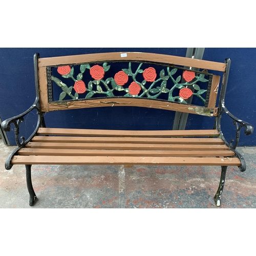 40 - A cast iron and wooden slatted garden bench with rose design back support - approx. 82cm high x 128c... 