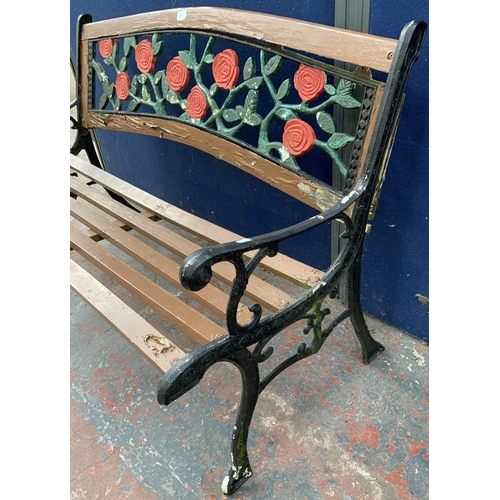 40 - A cast iron and wooden slatted garden bench with rose design back support - approx. 82cm high x 128c... 