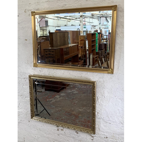 250 - Two modern gilt framed bevelled edge wall mirrors - largest approx. 65cm high x 94cm wide