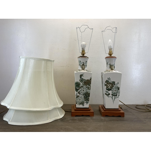 502 - A pair of Oriental style ceramic and teak table lamps with peacock and foliate design - approx. 65cm... 