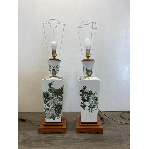 502 - A pair of Oriental style ceramic and teak table lamps with peacock and foliate design - approx. 65cm... 