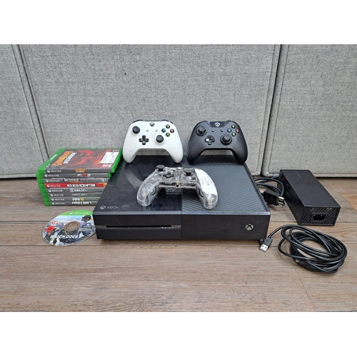 867 - A Microsoft Xbox One 1540 console with one third-party and two official controllers, games and power... 