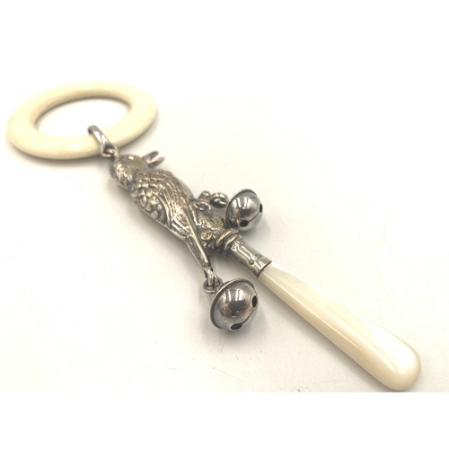 2135 - An antique hallmarked Birmingham silver bird design baby rattle with mother of pearl handle, white b... 