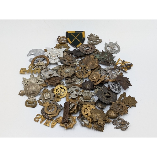 2206 - A quantity of of military cap badges and shoulder titles