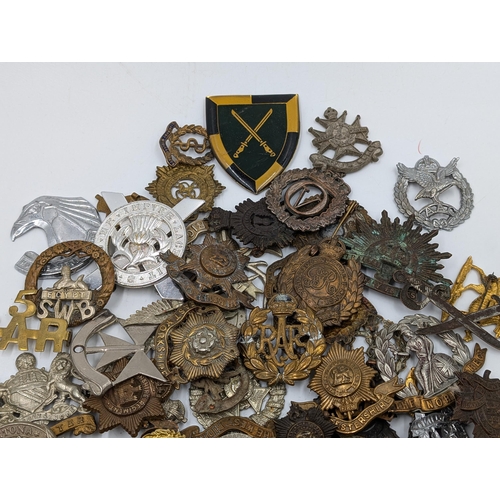 2206 - A quantity of of military cap badges and shoulder titles