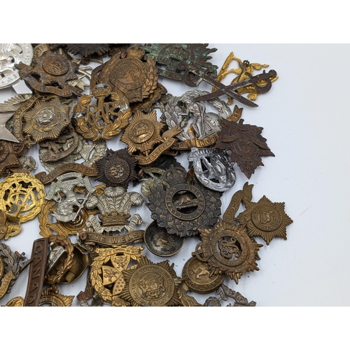 2206 - A quantity of of military cap badges and shoulder titles