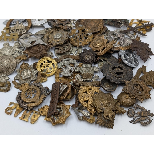 2206 - A quantity of of military cap badges and shoulder titles