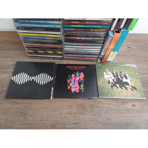 872 - A box containing a collection of CD albums and singles to include Arctic Monkeys, Foo fighters, Haim... 