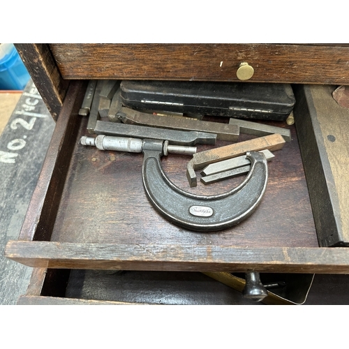 1053 - An early 20th century oak engineer's tool cabinet containing Moore & Wright callipers, tap and die s... 