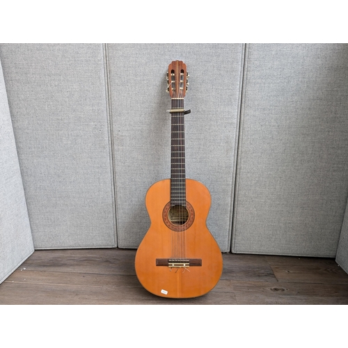 916 - A vintage Antoria 238 nylon strung classical guitar with capo