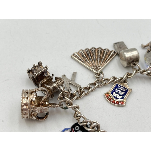 2051 - A hallmarked Birmingham sterling silver charm bracelet with heart shaped padlock clasp and assorted ... 