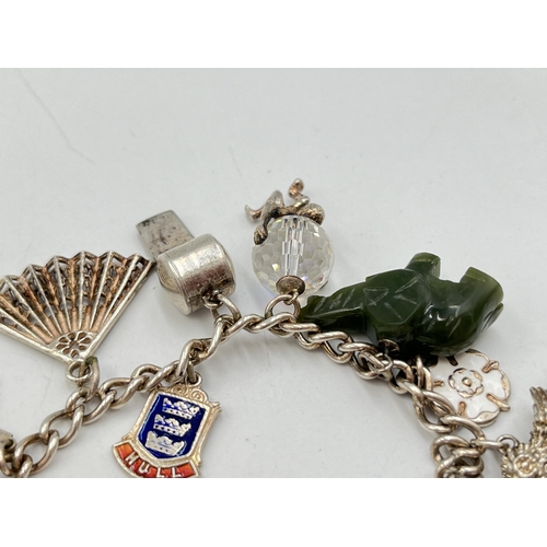 2051 - A hallmarked Birmingham sterling silver charm bracelet with heart shaped padlock clasp and assorted ... 